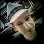 Profile picture from Bernhard. White straw hat, black Shirt with a smile.