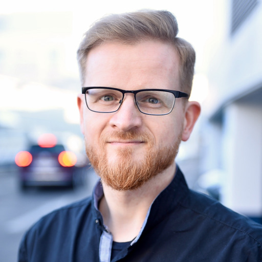 Black Glases, red, short hair, red beard in a black jacket